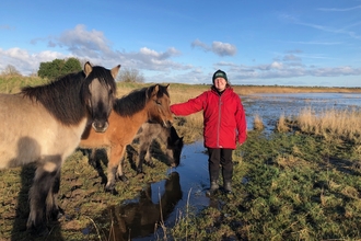 Residential volunteer, Emma Fowler, standing next to ponies