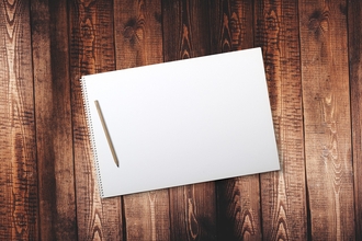 Notepad and pencil on a wooden background