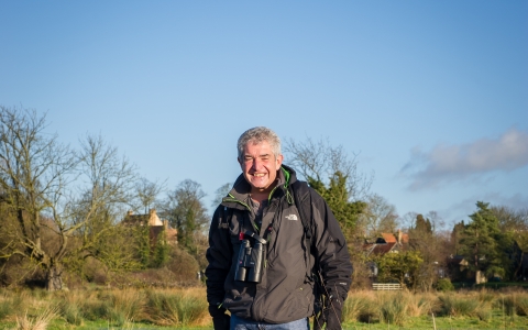 Tony stands in a wetland with his dogs