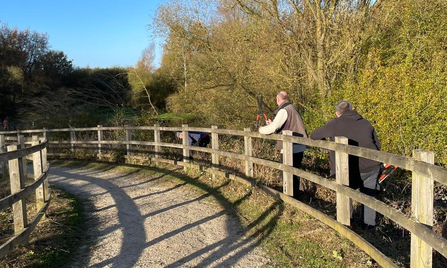 Whisby volunteers cutting back vegetation along the path sides on the railway bridge